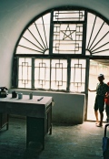 Boy looking at ’Mao’s desk after the long march’, at the caves in Yan’an